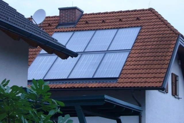Solarthermie-Anlage auf einem Ziegeldach eines Einfamilienhauses zur Warmwasserbereitung.